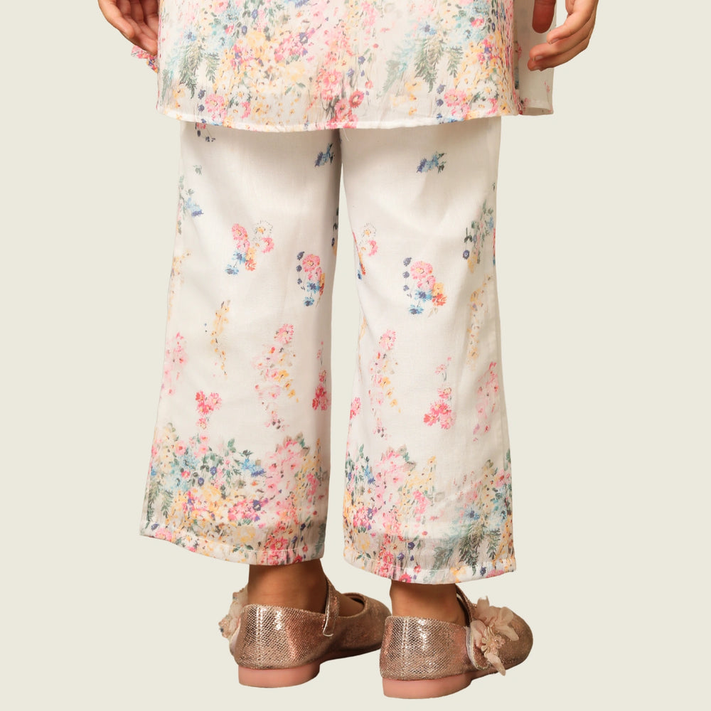 
                  
                     the Noor Kurti Set is a graceful ensemble perfect for dreamy celebrations. Set against a gentle white backdrop, the kurta features delicate multicolor floral prints scattered like wildflowers across the fabric. 
                  
                