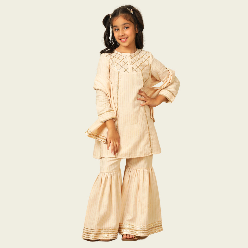 
                  
                    Elegant in its simplicity, the Rajni Sharara Set is a refined ensemble for special occasions. Crafted in a soft ivory-peach hue with subtle&nbsp;pinstripes, this set features a straight-cut kurta with delicate gold threadwork detailing on the yoke and sleeves. 
                  
                