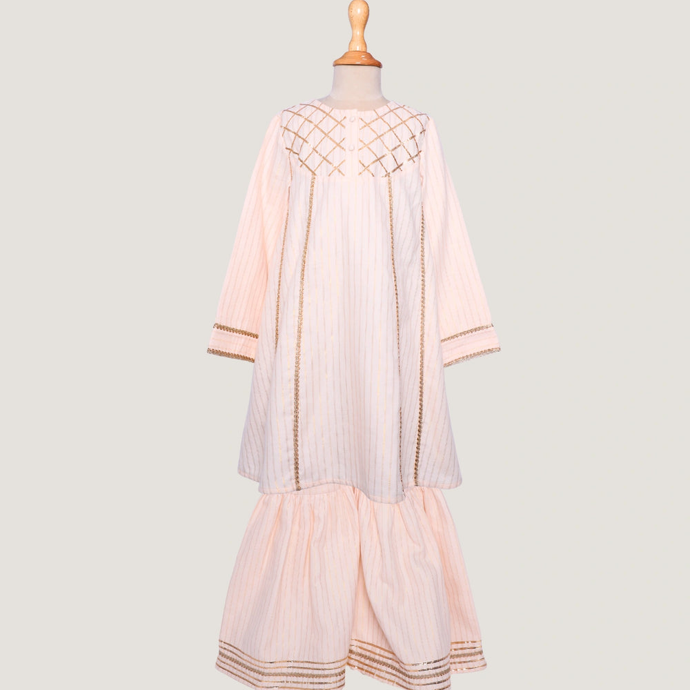 Elegant in its simplicity, the Rajni Sharara Set is a refined ensemble for special occasions. Crafted in a soft ivory-peach hue with subtle&nbsp;pinstripes, this set features a straight-cut kurta with delicate gold threadwork detailing on the yoke and sleeves. 