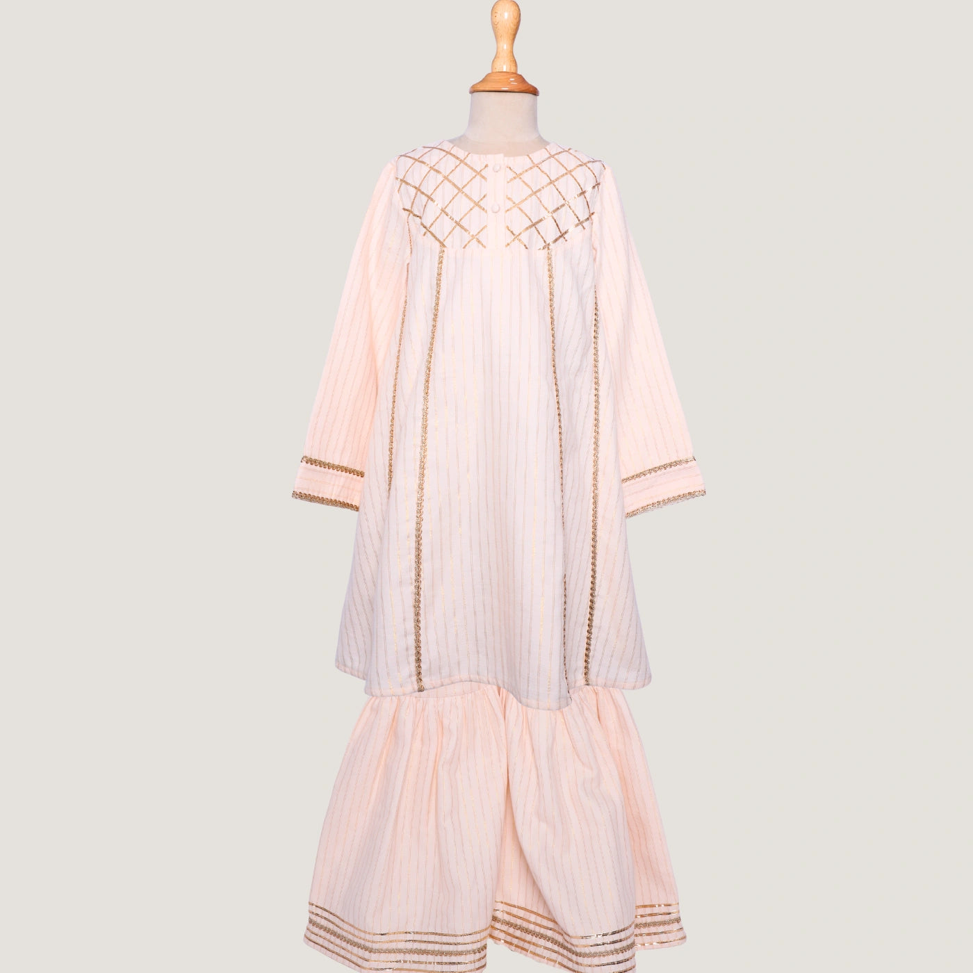 Elegant in its simplicity, the Rajni Sharara Set is a refined ensemble for special occasions. Crafted in a soft ivory-peach hue with subtle&nbsp;pinstripes, this set features a straight-cut kurta with delicate gold threadwork detailing on the yoke and sleeves. 
