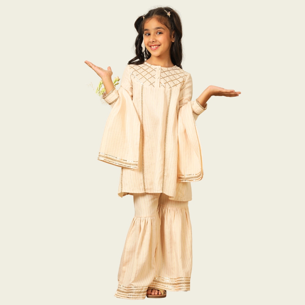 
                  
                    Elegant in its simplicity, the Rajni Sharara Set is a refined ensemble for special occasions. Crafted in a soft ivory-peach hue with subtle&nbsp;pinstripes, this set features a straight-cut kurta with delicate gold threadwork detailing on the yoke and sleeves. 
                  
                