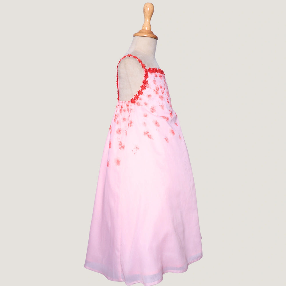 
                  
                    The Eira A-Line Dress is a playful ode to summer blooms. Crafted in a soft pink base, this sleeveless A-line dress features vibrant coral floral embroidery cascading from the neckline, with delicate flower appliqués adding texture and charm.
                  
                
