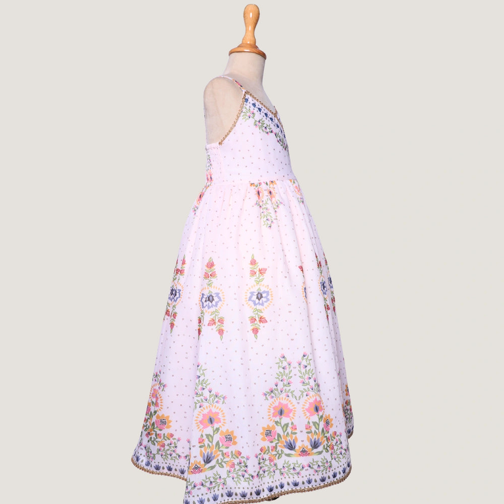 
                  
                     a graceful Indo-Western dress that blends tradition with whimsy. Crafted in soft, flowy Chanderi fabric, this dress features delicate floral prints, a flattering asymmetrical neckline, and dainty bead detailing along the straps and hem. 
                  
                