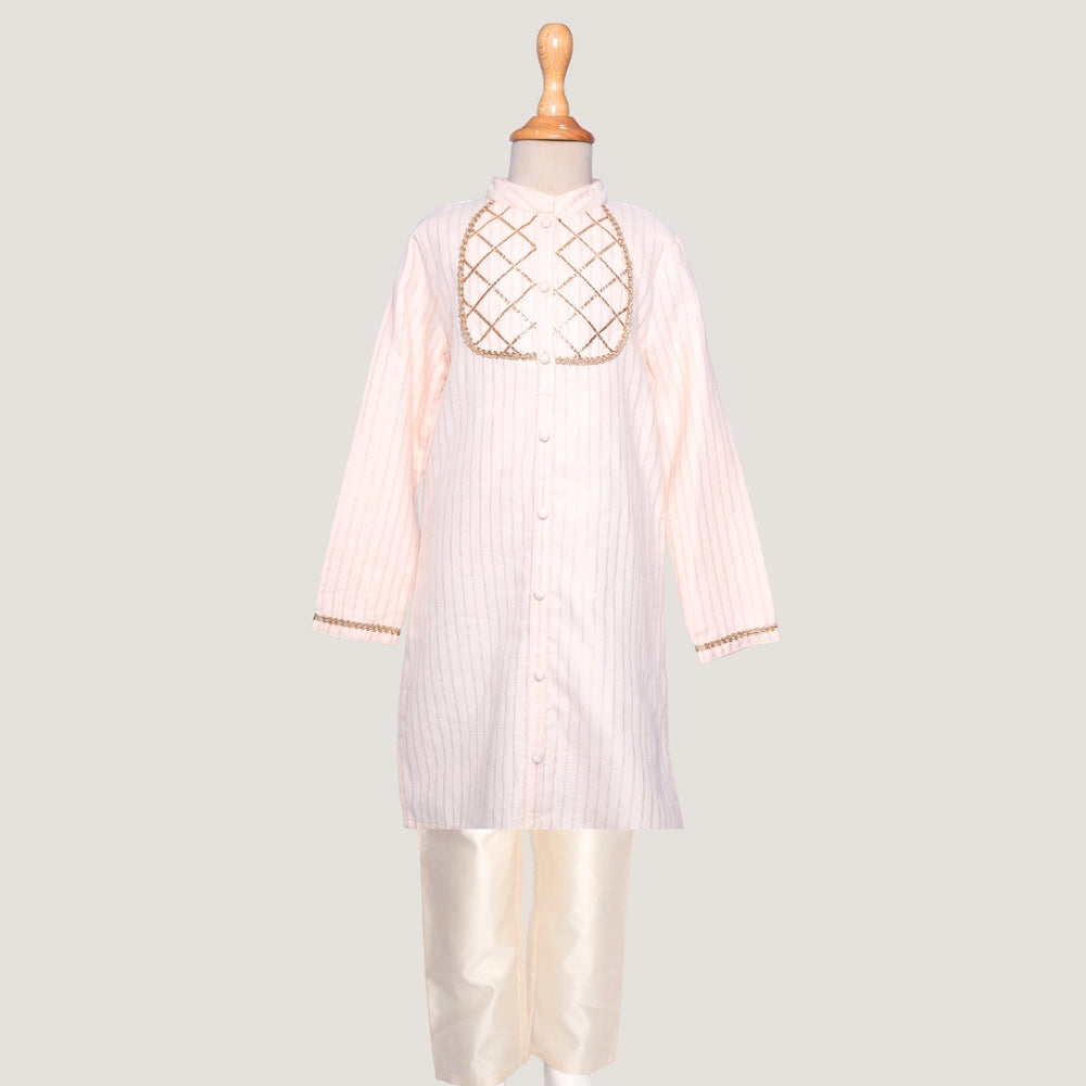 Elegant and timeless, this Rajni Gota kurta set for little boys is designed with delicate gota detailing that adds a festive sparkle. The kurta features a soft sheen and classic straight cut, paired with a comfortable churidaar for easy movement and all-day wear.
