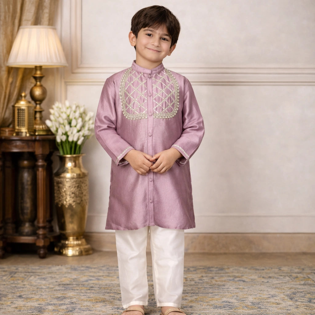 Young boy wearing a pink embroidered kurta with white pants in an elegant, mauve,gota, kurta, set, room.