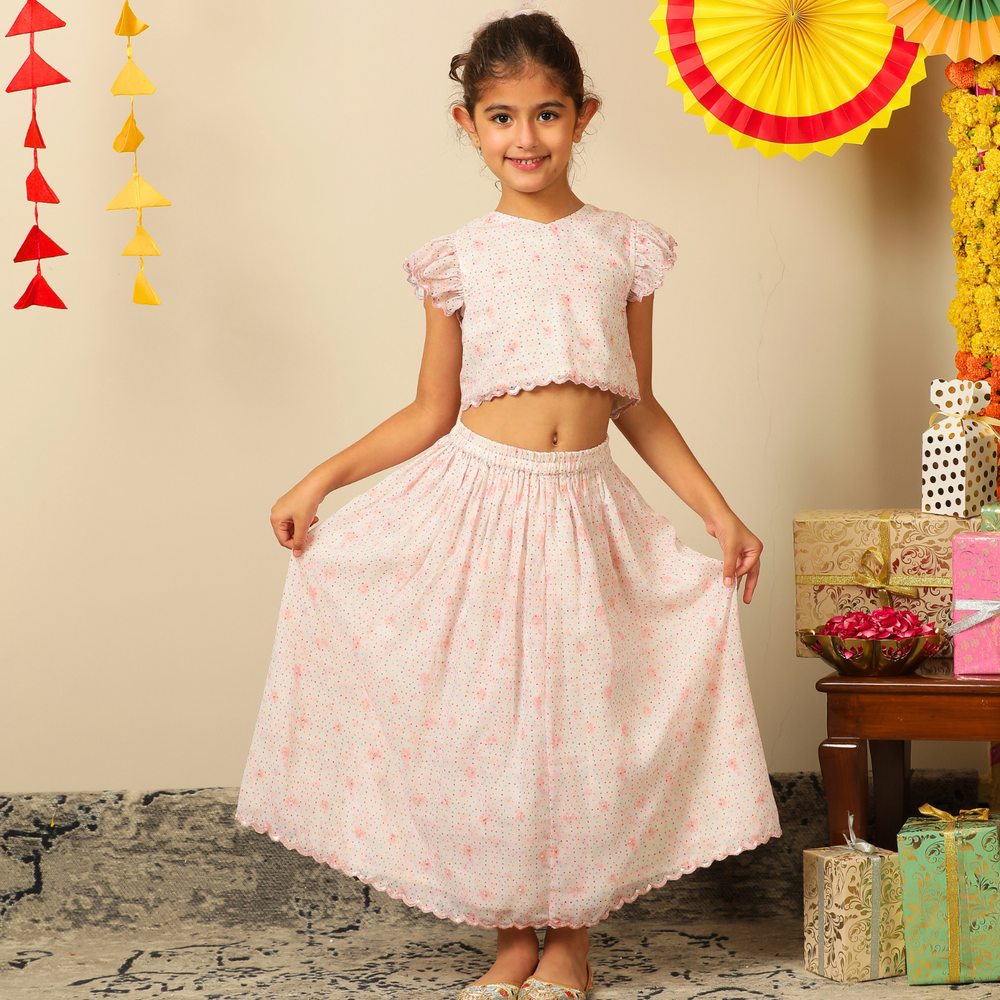 The Aabha Lehenga Dress Set is a sweet and sparkly outfit made for magical moments. Crafted in a soft pastel pink base, this dress is adorned with delicate floral prints and shimmering polka dots all over. 