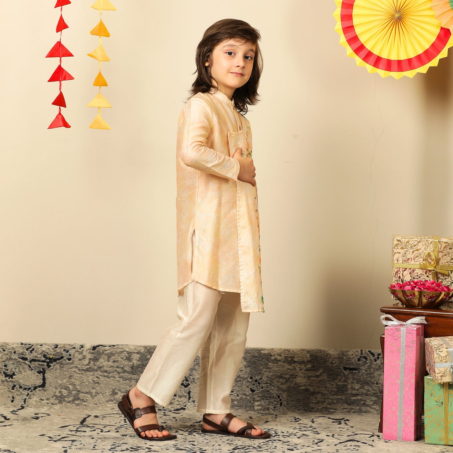 The Angrakha-style kurta for boys, features side tie detailing and a comfortable fit, paired with classic ivory pants for a clean, balanced look.