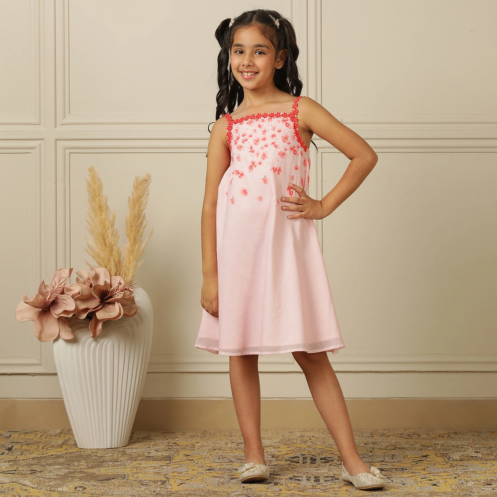 
                  
                    The Eira A-Line Dress is a playful ode to summer blooms. Crafted in a soft pink base, this sleeveless A-line dress features vibrant coral floral embroidery cascading from the neckline, with delicate flower appliqués adding texture and charm.
                  
                
