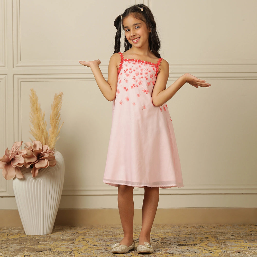 
                  
                    The Eira A-Line Dress is a playful ode to summer blooms. Crafted in a soft pink base, this sleeveless A-line dress features vibrant coral floral embroidery cascading from the neckline, with delicate flower appliqués adding texture and charm.
                  
                
