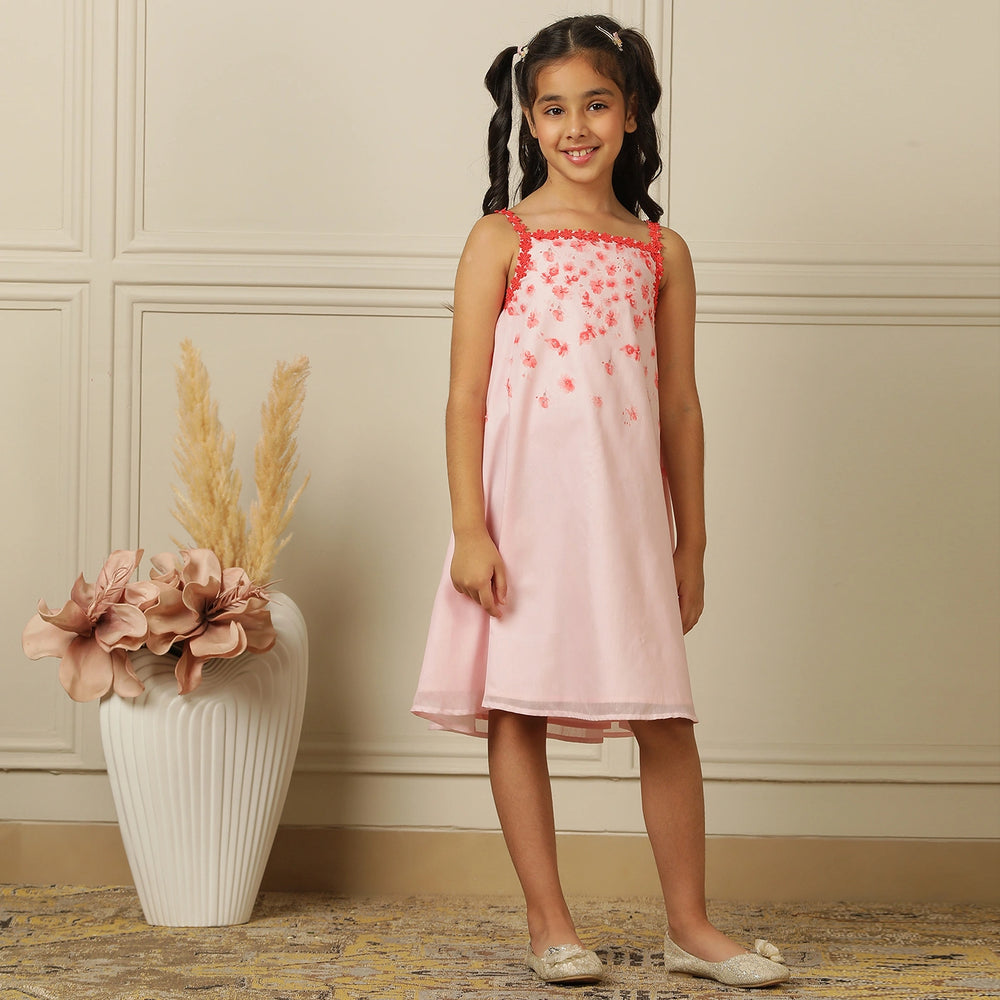 
                  
                    The Eira A-Line Dress is a playful ode to summer blooms. Crafted in a soft pink base, this sleeveless A-line dress features vibrant coral floral embroidery cascading from the neckline, with delicate flower appliqués adding texture and charm.
                  
                