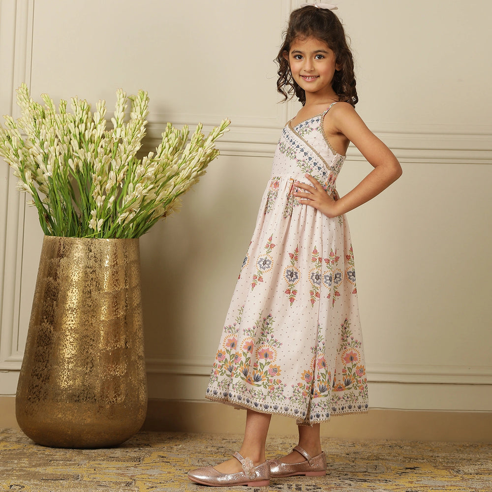 
                  
                     a graceful Indo-Western dress that blends tradition with whimsy. Crafted in soft, flowy Chanderi fabric, this dress features delicate floral prints, a flattering asymmetrical neckline, and dainty bead detailing along the straps and hem. 
                  
                