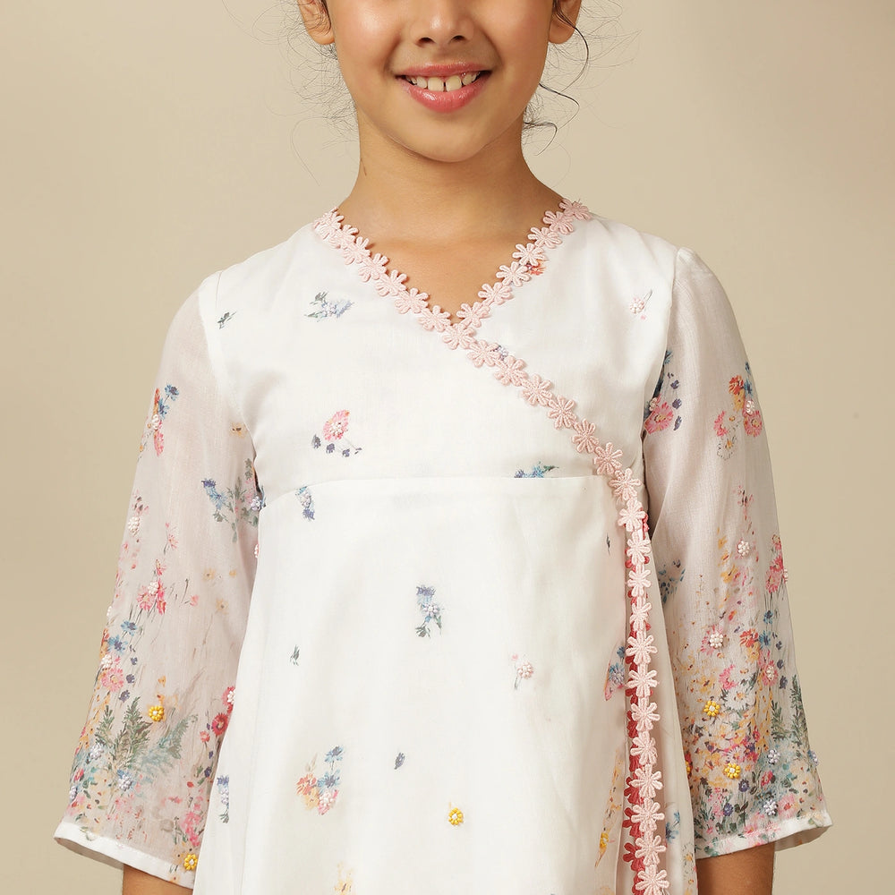 
                  
                     the Noor Kurti Set is a graceful ensemble perfect for dreamy celebrations. Set against a gentle white backdrop, the kurta features delicate multicolor floral prints scattered like wildflowers across the fabric. 
                  
                