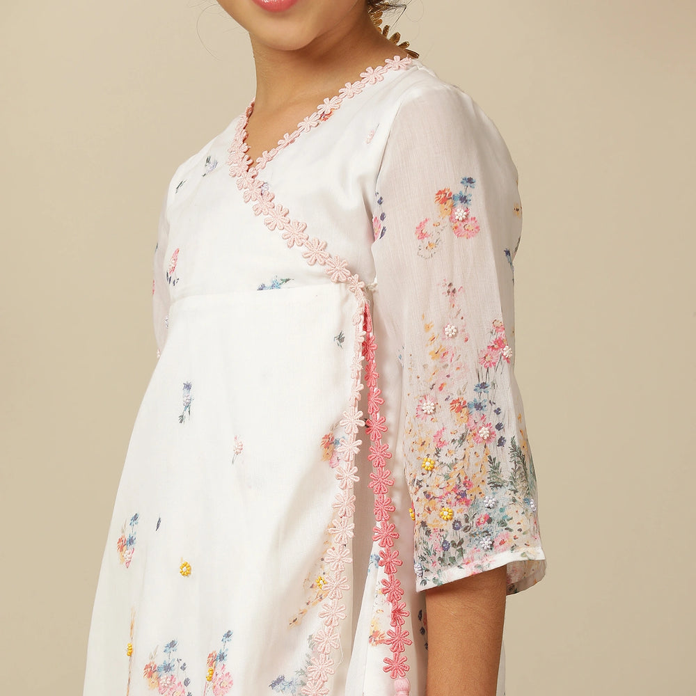 
                  
                     the Noor Kurti Set is a graceful ensemble perfect for dreamy celebrations. Set against a gentle white backdrop, the kurta features delicate multicolor floral prints scattered like wildflowers across the fabric. 
                  
                
